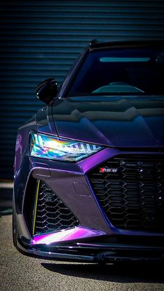 the front end of a purple sports car parked in front of a metal garage door