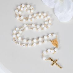 This Personalized Rosary, is ideal as a Baptism gift for a little girl or baby boy or as a gift for a special occasion. It is expertly handcrafted in a traditional style with a contemporary twist utilizing genuine Mother of pearl stone and gold-plated brass wire, which not only gives a touch of nature but also tenderness. The letter beads on the Rosary are also handmade from genuine mother of pearl, and the length is perfect to worn as a dainty Rosary necklace for women. *MATCHING ROSARY BRACELE Round Polished Bead Rosary As Gift, Polished Round Beads Rosary As Gift, Spiritual White Jewelry For Gifts, Spiritual White Jewelry As A Gift, White Round Beads Jewelry For Mother's Day, Spiritual White Cross Jewelry, Gift Rosary With 8mm Round Beads, Rosary With 8mm Round Beads As Gift, 8mm Round Bead Rosary As Gift