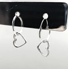 Add a touch of timeless sophistication to your jewelry collection with our exquisite 925 Sterling Silver Heart Hoop Earrings. Crafted with precision and love, these earrings feature a beautifully delicate design measuring 15/32 inches in width and 25/32 inches in length, perfectly capturing the essence of minimalist elegance. Stamped with the 925 hallmark, these heart hoop earrings guarantee the highest quality of sterling silver, ensuring they remain a cherished piece for years to come. Made for both everyday wear and special occasions, these sterling silver heart hoops are incredibly versatile. Whether you're dressing up for a romantic dinner or adding a subtle sparkle to your casual outfit, these earrings will effortlessly elevate your look. The secure clasp ensures they stay in place, Anniversary Heart Charm Hoop Earrings, Anniversary Hoop Earrings With Heart Charm, Hypoallergenic Hoop Earrings For Valentine's Day Anniversary, Dainty Hoop Earrings For Valentine's Anniversary, Pierced Hoop Heart Earrings For Anniversary, Pierced Open Heart Hoop Earrings For Anniversary, Anniversary Open Heart Pierced Hoop Earrings, Anniversary Open Heart Hoop Earrings, Silver Hoop Earrings For Valentine's Day