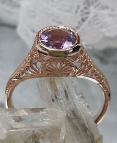 Natural Purple Amethyst Ring Dandelion Design #205 Made To Order This exquisite ring is a beautiful replica of Edwardian wedding jewelry, crafted with intricate filigree detail. The center stone is a .52ct natural purple amethyst, measuring 6mm in diameter. The ring is made with a combination of rose gold plating and sterling silver, stamped with the mark 925 on the inner shank. The rose gold and sterling silver filigree setting truly showcases the stunning craftsmanship of this piece. This orna Gold Amethyst Ring With Center Stone For Wedding, Amethyst Rings With Intricate Design For Wedding, Gold Amethyst Ring For Wedding, Gold Amethyst Ring For Wedding, Round Cut, Heirloom Gold Amethyst Ring For Weddings, Purple Diamond Cut Jewelry For Wedding, Heirloom Amethyst Ring With Intricate Design For Wedding, Classic Amethyst Wedding Ring With Diamond Cut, Intricate Amethyst Wedding Ring