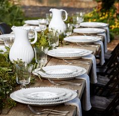 the table is set with white dishes and glassware