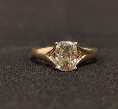 a close up of a ring with a diamond in it on a black cloth background