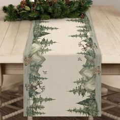 a christmas table runner with pine cones and evergreen leaves