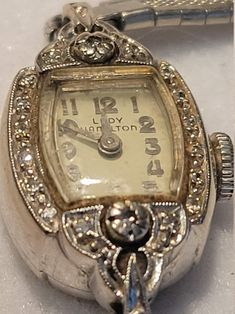 "Vintage \"Lady Hamilton\" 17 Jewel 14K Biggs White Gold Ladie's Wrist Watch, with diamonds.  Admittedly, this needs cleaning up.  Watch runs.  I did not open back to view the mechanism.  Not sure how the back opens, so I devided to just leave it alone.  This was a 25 year service gift for my great aunt, an employee at Callaway Mills in LaGrange, GA.  (It is engraved on the back to her)." Gold Wrist Watch, Lady Hamilton, Art Deco Watch, Vintage Jewelry Ideas, Gold Diamond Watches, Antique Costume Jewelry, Hamilton Watch, Watch Jewelry, Vintage Lady