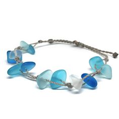 Channel your inner mermaid with this gorgeous beach bracelet or anklet made with mixed blues and white sea glass pebbles on our durable hand spun rope cord. Pure island style! Easy and secure adjustable slide knot closure allows for easy on and off. This bracelet/anklet is completely waterproof and metal free making it perfect for anyone with skin sensitivities and is a wonderful and unique gift for those hard to shop for friends and family on your list, especially the beach lovers! Color: Mixed Adjustable Blue Beachy Jewelry, Blue Adjustable Beachy Jewelry, Beachy Blue Adjustable Jewelry, Handmade Adjustable Sea Glass Bracelets, Adjustable Blue Beach Jewelry, Beach Jewelry Blue Hand-wrapped, Adjustable Blue Jewelry For Beach, Adjustable Blue Jewelry Made Of Recycled Glass, Adjustable Blue Recycled Glass Jewelry