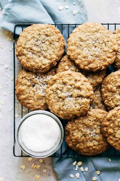 oatmeal cookies on a cooling rack with a glass of milk next to it