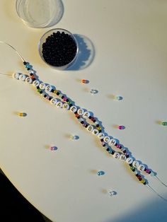 the beads have been placed on the table to make it look like they are made out of letters