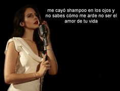 a woman in a white dress holding a microphone with the words, me cayo shampo en los os os os y no sabs