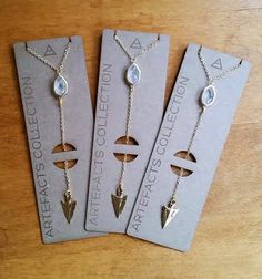 three different necklaces are sitting on top of each other in front of a card