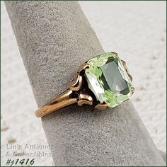 I purchased this vintage ring over 30 years ago at a local antique store that has long since closed. I fell in love with the vintage mounting and the beautiful light green color stone. Unlike most of my rings that I have listed, I actually wore this ring on a somewhat regular basis.  The green stone was listed as peridot. It measures 3/8" x 5/16" and is emerald cut. The band measures 1/16" at bottom and is marked 10k. The ring is size 7 (sorry, when I listed this ring, I listed the size in the i Collectible Green 14k Stamped Jewelry, Victorian Green Jewelry Stamped 14k, Antique Green Emerald Cut Ring, Antique Green Emerald Cut Emerald Ring, Antique Emerald Cut Green Emerald Ring, Antique Green Emerald-cut Emerald Ring, Green Peridot Birthstone Ring For Formal Events, Green Peridot Birthstone Ring For Formal Occasions, Heirloom Green Ring For May Birthstone