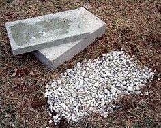 two cement blocks sitting on top of a grass covered field next to a pile of rocks