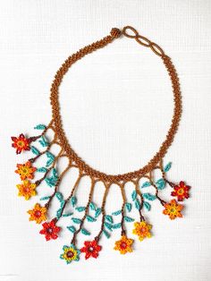 The Jardín (Garden) Necklace will bring any neutral outfit to life with a burst of color! These necklaces are made by Inga Awaska, Inga Women Artisans from Putumayo, Colombia. Details: - Material: Seed Beads - Ball and Loop Closure (look carefully, most have two loops for adjusting the size, but can vary between 1-3 loops). Bohemian Brown Flower Necklace, Multicolor Beaded Necklaces With Nature-inspired Style, Handmade Multicolor Beaded Necklaces, Nature-inspired, Handmade Multicolor Nature-inspired Beaded Necklaces, Bohemian Multicolor Flower Necklace, Multicolor Bohemian Flower Necklace, Bohemian Orange Flower Beaded Necklace, Bohemian Orange Flower Necklace, Orange Bohemian Flower Necklace