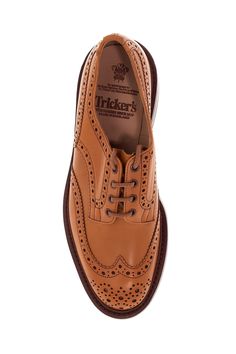 The Bourton derby lace-up shoes by Tricker's are made of antiqued Acorn leather with brogue punching and a gusseted tongue sewn to the shoe. The lining is full-grain leather, while the insole features padded heel support. They have a Goodyear construction with waterproof stitching, a full-grain leather midsole with cork padding, and a studded Dainite rubber sole. Composition: 100% calfskin Brown Goodyear Welted Lace-up Derby Shoes, Brown Goodyear Welted Oxford Lace-up Shoes, Brown Wingtip Lace-up Shoes With Leather Lining, Brown Wingtip Leather Derby Shoes, Timeless Brown Oxford Lace-up Shoes, Brown Lace-up Derby Shoes With Leather Sole, Brown Leather Sole Lace-up Shoes For Derby, Timeless Brown Lace-up Oxford Shoes, Brown Goodyear Welted Oxfords For Derby