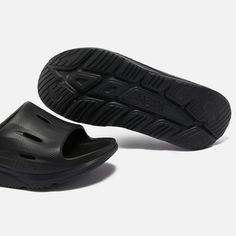 Created from EVA, Hoka One Ora slides feature oversized midsoles and sculpted soles for a futuristic appearance. They offer supreme comfort with a higher footbed of soft cushioning..Style Notes:.Hoka One Ora recovery slides.Black EVA.Designer logos, perforations, rubber soles.Size & Fit:.Slip on Textured Sole Slides For Streetwear, Comfortable Slides With Textured Sole For Streetwear, Modern Slides With Branded Insole For Streetwear, Modern Synthetic Slides For Streetwear, Sporty Slides With Textured Sole For Streetwear, Modern Slides With Rubber Sole For Streetwear, Modern Rubber Sole Slides For Streetwear, Slides With Textured Sole And Round Toe For Streetwear, Modern Black Slides With Textured Footbed