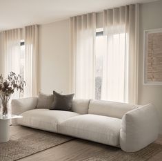 a large white couch sitting in front of two windows