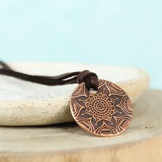 This simple yet stunning mandala necklace is the perfect piece to keep you centered. A mandala is a sacred space, often a circle, which reveals inner truth about you and the world around you. Speak, the universe is listening. ❤ 23mm Copper disc with mandala pattern ❤ 3mm Deer skin lace - choose your length To order yours, choose your options & add it to your cart. Choose your shipping method, and check out. Holistic Jewelry With Adjustable Cord For Meditation, Bohemian Engraved Copper Necklaces, Spiritual Necklace With Adjustable Cord, Adjustable Medallion Necklace For Healing, Adjustable Medallion Necklaces For Healing, Bohemian Bronze Medallion Necklace For Gift, Bohemian Bronze Medallion Necklace As Gift, Adjustable Spiritual Medallion Pendant Necklace, Spiritual Copper Necklace With Round Pendant