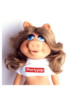 a close up of a doll wearing a shirt with the word shortypop on it