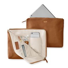 The best gifts are always the ones that make your life infinitely easier - like this beautiful leather clutch that doubles as a super-functional tech organizer. The zip-around closure opens to reveal multiple interior open and zipped pockets, leather tabs, card slots and plenty of space for your phone, keys, cards, cash, chargers, and other daily essentials. Add a foil debossed monogram for a personal touch.    11"w x 1"d x 9"h  Leather or suede exterior with a grosgrain lining.  See Product Inf Travel Makeup Bag Leather, Leather Handbags Women Travel, Leather Gifts For Home, Leather Art Supplies Bag, Modern Desk Accessories Leather, Bag For Mac, Leather Sewing Accessories, Gifts To Sew For Travelers, Sewing Christmas Gifts For Women