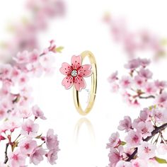 a pink flower ring sitting on top of a white table next to some pink flowers