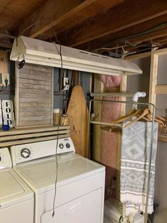 a washer and dryer in a small room with unfinished wood flooring on the walls