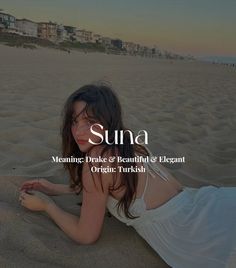 a woman laying on top of a sandy beach