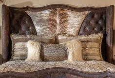 a bed with two pillows on top of it and an animal print pillow in the middle