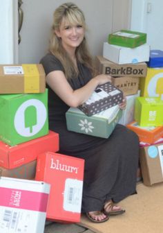 a woman sitting on the floor with many boxes