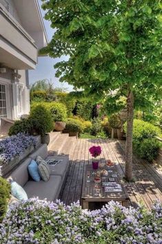 an outdoor living area with couches, tables and flowers