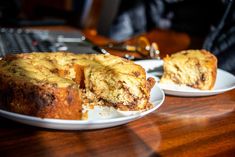 two white plates with slices of cake on them sitting on a table next to a keyboard