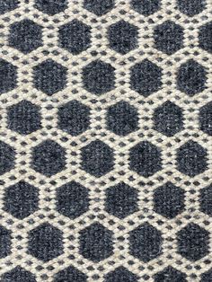 an upholstered black and white rug with hexagonal shapes