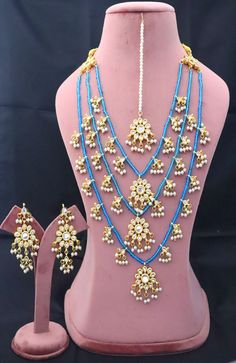 Tahmina Kundan Long Necklace Earrings Tika Pearls Jewelry, 3 Layers Turquoise Indian Jewelry, Bridal Wedding Handmade Jewelry Christmas Set ITEM DESCRIPTION Metal = Gold Plated Occasion = Wedding ,Party Wear, Bridal Color = White and Turquoise Size = Necklace Length = 28 CM Earrings/Studs = 7 CM Tika = 10 CM 100% Satisfaction Guarantee: 1 Year Warranty, Long Lasting Plating, High-Quality Stones Occasion: Perfect choice for any Indian occasion. Care: It is advisable that you keep products away fr Turquoise Earrings For Wedding And Festivals, Blue Kundan Necklace For Celebration, Turquoise Kundan Bridal Necklace For Festive Occasion, Festive Turquoise Kundan Bridal Necklace, Festive Turquoise Chandbali Jewelry, Turquoise Jewelry With Latkans For Festivals, Traditional Turquoise Jewelry Sets For Festive Occasions, Turquoise Latkans Jewelry For Festivals, Festive Turquoise Jewelry With Latkans