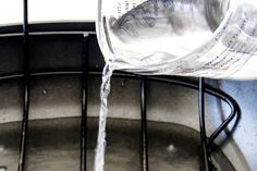 water is being poured into a glass container