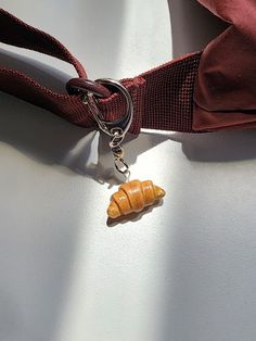 a piece of food is attached to a lanyard with a keychain on it