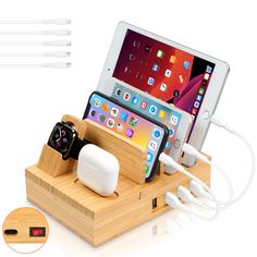 an electronic device charging in a wooden docking station with apple watch and ear buds on it