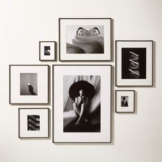 black and white photographs hang on the wall above a woman's head with an umbrella