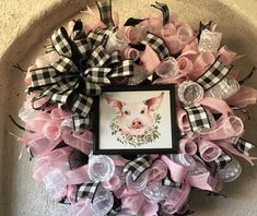 a pink and black wreath with a pig on it