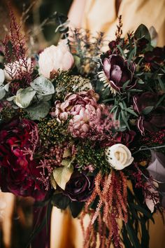 a woman holding a bouquet of flowers in her hands