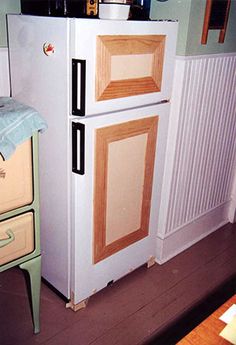 a white refrigerator freezer sitting inside of a kitchen next to a wooden counter top