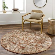 a living room with a chair, mirror and rug on the wooden floor in front of a window