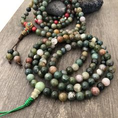 Beautiful Mix Jade Japa Mala from Nepal. You can choose between the mala that has unique mix metal beads and a main Nepali metal bead at the bottom of the mala necklace. Or the mix Jade mala that is all stone beads with no metal beads. A unique praying mala that can be used as a necklace or as an ornament. The mala has no clasp, you wear it over the head. The Mala with the metal beads and the red beads has a total length of 49cm- 19.25 inch long The mala that is all stone beads is 43cm- 17 inch Green Spiritual Beads For Healing, Green Spiritual Beads, 108 Count, Holistic Beaded Bracelets With Round Beads For Meditation, Multicolor Jade Beaded Necklaces With Round Beads, Green Mala With 8mm Beads For Healing, 8mm Jade Beads For Spiritual Use, Spiritual Hand-strung Jade Beaded Necklace, Multicolor Polished Beads Bracelet For Meditation, Multicolor Polished Beaded Bracelets For Meditation