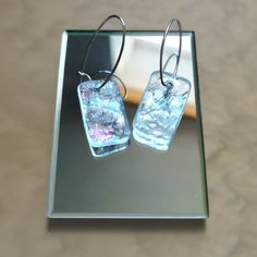 The images of this item are a representation of the design, very close to what we will create specifically for you. We do not make copies. Each item in our store is unique, and it can be customized according to your choice (colors, number, size of particles). These handmade glass earrings are the perfect accessory for any outfit. Made of transparent stained glass with mother-of-pearl on one side. They are easy. The hoops are made of silver. These earrings are unique because the artist cannot reproduce the pieces of glass exactly the same and the sizes can vary because no stencils are used. Each piece is made in only one example. Size: 1 x H 1.5 h '' / 1.5 x 2.5 cm , ring 1.5 '' / 2.5 cm Modern Glass Earrings For Gifts, Nickel-free Silver Earrings With Recycled Glass, Nickel-free Silver Earrings In Recycled Glass, Glass Drop Earrings For Gift, Modern Handmade Glass Earrings, Modern Nickel-free Glass Earrings, Modern Clear Earrings As Gift, Modern Clear Earrings As A Gift, Modern Clear Earrings For Gifts