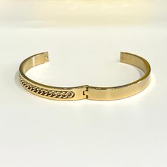 Bring home this magnificent bangle bracelet. Featuring a polished curb chain inlay design this bracelet is made from stainless steel. This is a seriously pretty bangle that is easy way to dress up any outfit, it makes a beautiful gift or a special treat for yourself.- Metal: Stainless Steel.- Plating: 18k Gold plated.- Inner Diameter: 64 mm.- Width: Aprox. 8 mm.- Clasp: Snap Closure.- Circumference Inches: 7.85 Ships in a Balara Gift Pouch.Available in Gold.SKU# B1781 Chic Stainless Steel Jubilee Bracelet, Gold Stainless Steel Bangle, Tarnish Resistant, Chic Stainless Steel Bangle Bracelet, Tarnish Resistant Stainless Steel Gold Bangle, Luxury Metal Bangle Chain Bracelet, Trendy Gold-plated Tarnish-resistant Bangle, Chic Stainless Steel Bangle Jewelry, Tarnish Resistant Stainless Steel Cuff Bracelet, Gold Cuff Bracelet With Chain Detail