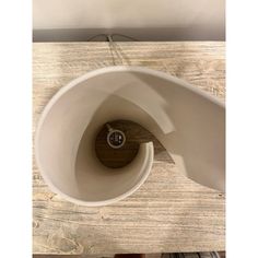 a close up of a white cup with a wooden handle on a wood table top