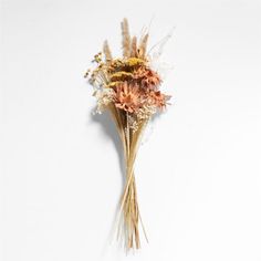 dried flowers are arranged on a white surface