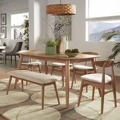 a dining room table with four chairs and a bench in front of a window overlooking the mountains