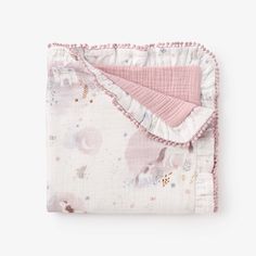 a pink blanket with white ruffles and stars on it, folded up in front of a white background