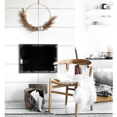 a living room with white walls and black and white decor, including a large flat screen tv