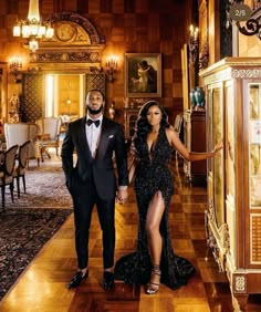 a man and woman in formal wear walking through a room