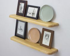 three wooden shelves with pictures and plates on them