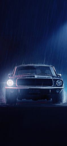 a car driving in the rain at night with its headlights turned on and it's hood up